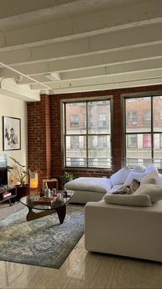 a living room filled with furniture and large windows