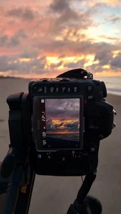 a camera is set up to take a photo on the beach at sunset or sunrise