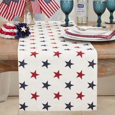 an american flag table runner with red, white and blue stars in the center on a dining room table