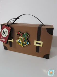 a cardboard box with hogwart's crest and harry potter badge on the front