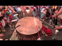 a group of people sitting around a drum