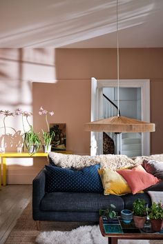 a living room filled with furniture and lots of plants