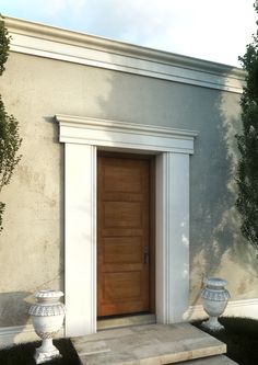 an entrance to a house with two urns