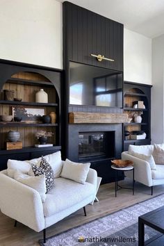 a living room with two white couches and black bookcases on the wall