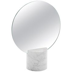 a round mirror sitting on top of a marble pedestal