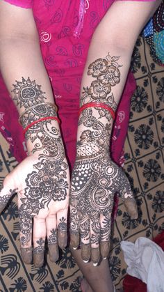 two hands with henna tattoos on them