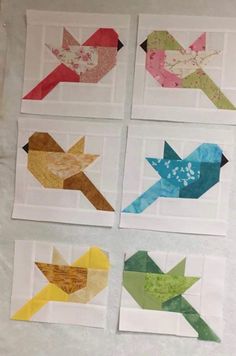 four pieces of paper with different colors and shapes on them, one has an arrow in the middle