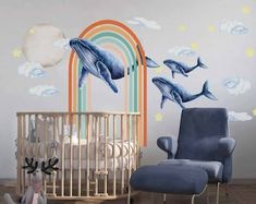 a baby's room with dolphin decals on the wall and a crib