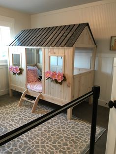 a child's bed made out of wood with pink flowers on the top and bottom