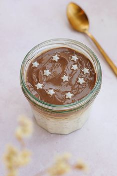 a jar filled with chocolate pudding next to a spoon