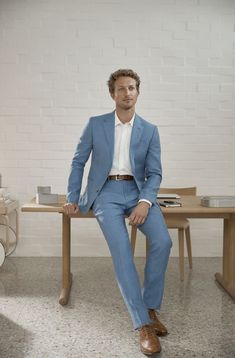 a man in a blue suit sitting on a table