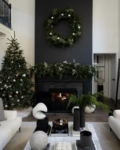 a living room filled with furniture and a christmas tree in front of a fire place