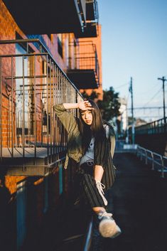 a woman leaning up against the side of a building