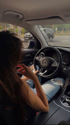 a woman sitting in the driver's seat of a car