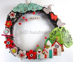 a wreath with houses, flowers and butterflies hanging on the front door to spell out home