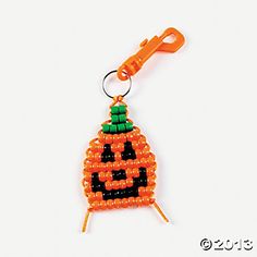 an orange beaded pumpkin ornament hanging from a hook on a white background