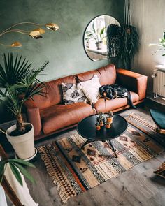 a living room filled with furniture and potted plants on top of rugs in front of a round mirror