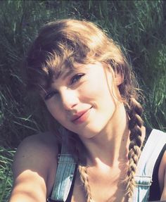 a woman with braids sitting in the grass