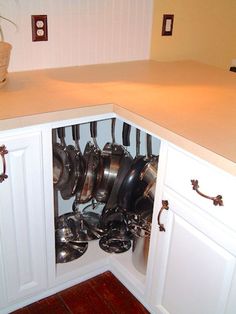 an open cabinet with pots and pans in it