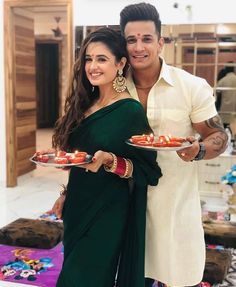 a man and woman holding plates with food on them