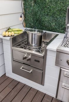 an outdoor kitchen with pots and pans on the burner, oven and grill