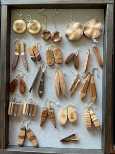 a shadow box filled with lots of wooden earrings