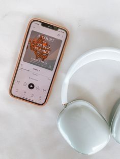 an mp3 player and headphones sitting on a white surface next to each other,