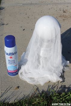 a plastic ghost with a spray bottle on the ground next to it's head