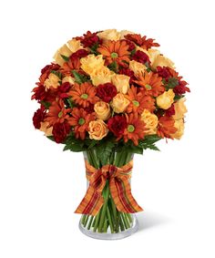 a vase filled with lots of orange and red flowers