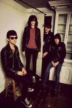 an image of three people sitting on a chair in front of a cabinet and door