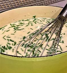 a whisk in a bowl filled with cream sauce