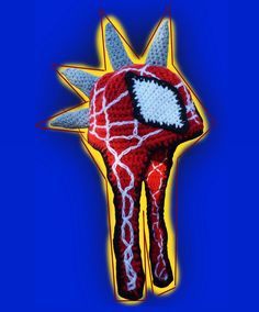 a crocheted red and white giraffe head on a blue background