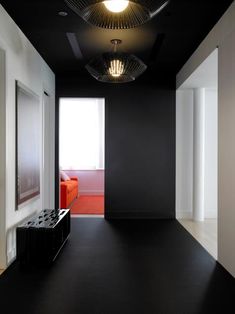 an empty room with black walls and white floors