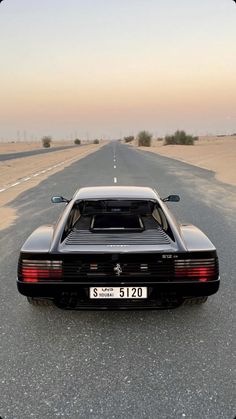 a black sports car parked on the side of an empty road