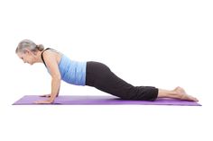 an older woman is doing yoga on a purple mat