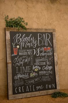 a chalkboard sign that is on the side of a wall next to a potted plant