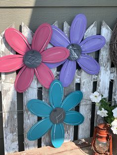 colorful flowers are painted on the side of a wooden fence