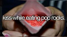 a person holding up a pink paper bag with candy in it and the words kiss while eating pop rocks