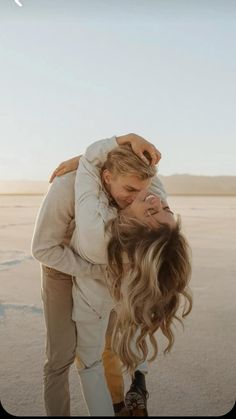 two people are hugging each other on the beach