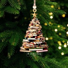 a christmas tree ornament made out of books is hanging from a fir tree