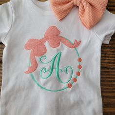 Shirt features a large Bow wreath surrounding your choice of single letter monogram. Available in a range of sizes from infant to youth. Listing is for shirt only. Colors in photos may appear differently on different devices. Single Letter Monogram, Monogram Shirt, Bow Wreath, Monogram Shirts, Letter Monogram, Monogram Wreath, Single Letter, Shirt Embroidery, Wreath Bow