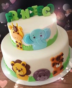 a three tiered cake decorated with animals and letters