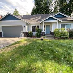 a house that has grass in front of it and two garages on the other side