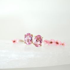 Small oval pink tourmaline stud earrings in yellow gold with pushback. Tourmaline is the birthstone of October, a great birthday gift for October birthdays. A beautiful pink color, each stone measures 6 x4 mm set into a fancy style prong mounting. Genuine Tourmaline 6x4mm Pink Slightly included 14k Yellow Gold Fancy Mounting Ready to ship :: In the PERSONALIZED SECTION- Please enter any specifications, time frames, and or change of address. We NOW offer Vintage Jewelry from our former ByDesignLA October Birthdays, White Topaz Earrings, Mom Ring, Oval Stud Earrings, Tourmaline Earrings, Topaz Earrings, Couture Jewelry, Change Of Address, Birthstone Earring