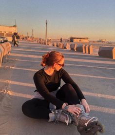 a woman sitting on the ground with her skateboard