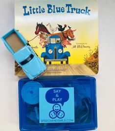 a blue toy truck sitting on top of a wooden table next to a card game