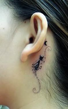 a woman with a cat tattoo on her left behind the ear