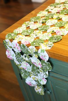 a kitchen counter with paper flowers on it and a wooden cutting board in the background