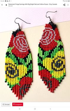 two pairs of beaded earrings with red and yellow flowers on them, hanging from hooks