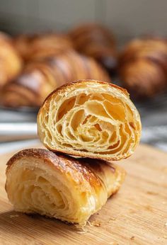 two croissants sitting on top of a wooden cutting board